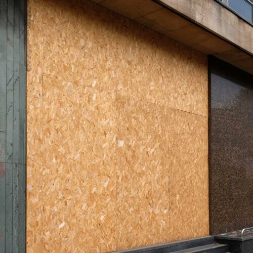 Boarded-up residential window close-up