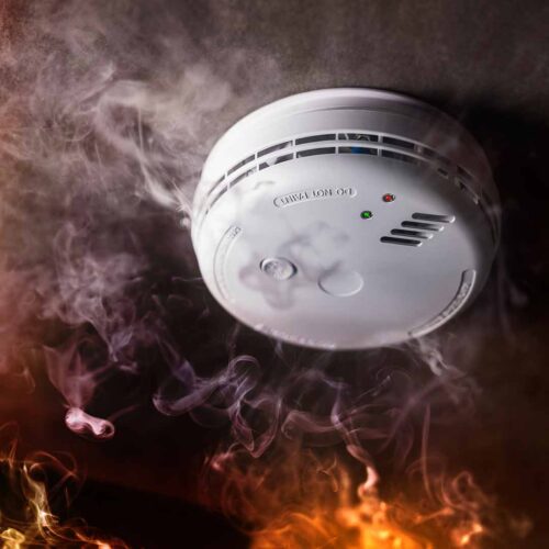 Smoke detector with smoke in background