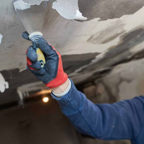 Hand using infrared thermometer on damaged surface