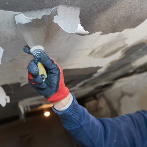 Hand using infrared thermometer on damaged surface