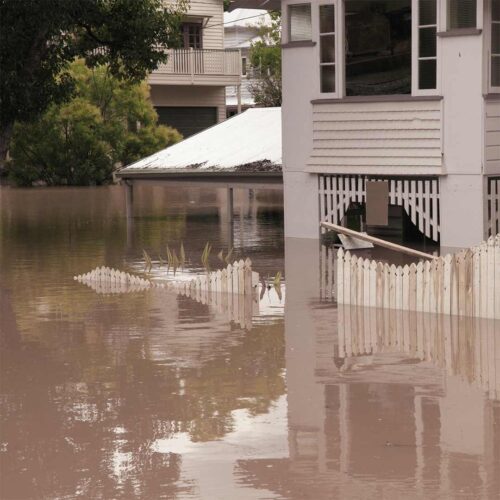 Residential flood damage with standing water surrounding home and submerged yard