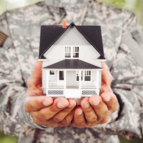 Hands holding model house